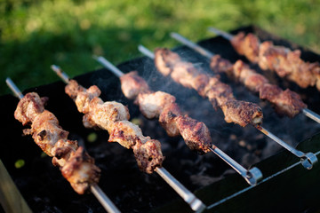 barbecue on skewers is fried on a grill in the summer