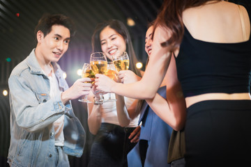 Group Asian girl gang and boyfriends  holding glasses with champagne and cheering with them while having party alcohol. night lifestyle concept.