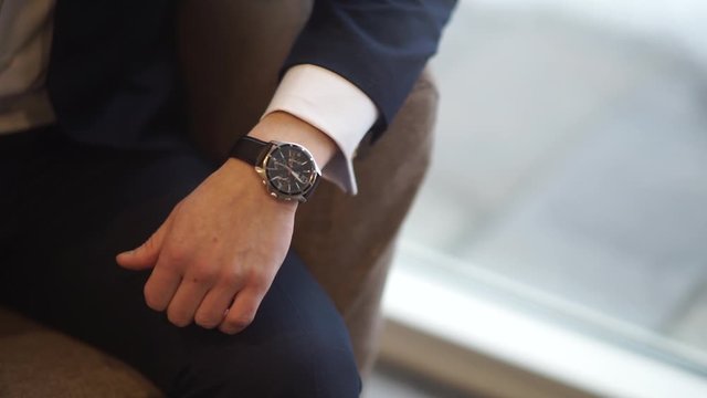 watch on the hand of a sitting man