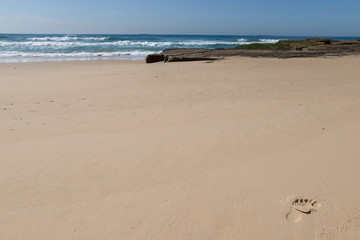 food print on the beach and sea