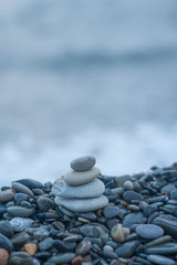 pyramid of stones by the sea at dawn. balanced zen stones. 