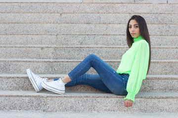 Portrait of confidence caucasian woman with ideal slim sexy body, wearing longsleave shirt and jeans. With dark hair, outdoor, winter clothing.