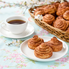 Fototapeta na wymiar Cinnamon buns with tea and spring flowes
