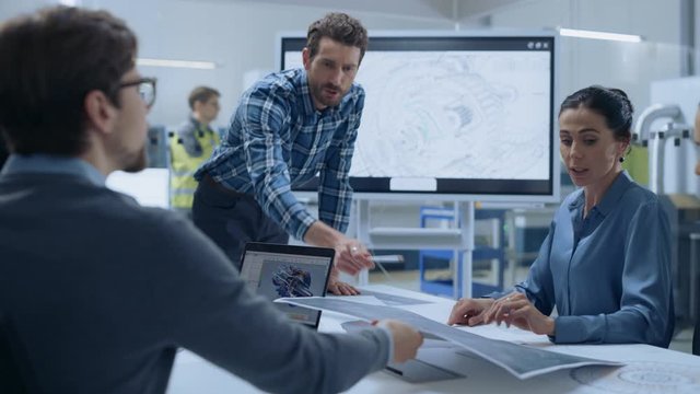 Modern Factory Office Meeting Room: Diverse Team of Engineers, Managers and Investors Talking at Conference Table, Use Interactive TV, Analyze Sustainable Energy Engine Blueprints. High-Tech Facility