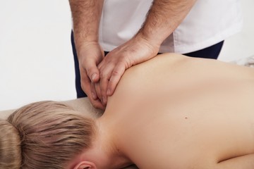 Osteopath does back and shoulder massage to a girl
