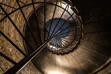 Medieval spiral staircase in the tower. stone step. metal handrail.