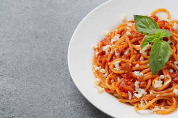 Tasty classic italian spaghetti pasta with tomato sauce, cheese Parmesan and basil. 