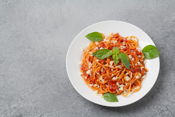 Tasty classic italian spaghetti pasta with tomato sauce, cheese parmesan and basil. 