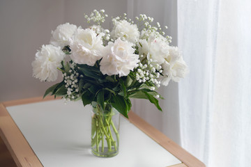White peonies flowers with Gypsophila in vase on white background