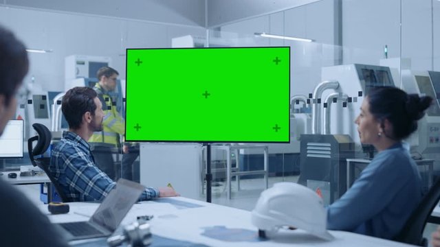 Modern Factory Office Meeting Room: Diverse Team of Engineers, Managers and Investors Talking at Conference Table, Watching Interactive TV that shows Green Screen Chroma Key Mock-up
