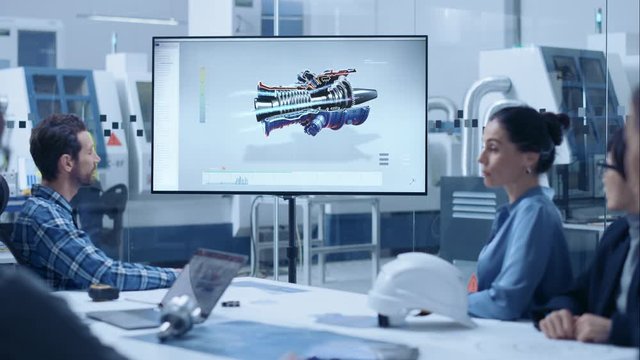 Modern Factory Office Meeting Room: Diverse Team of Engineers, Managers and Investors Talking at Conference Table, Watching Interactive TV that shows Sustainable and Renewable Green Energy Engine