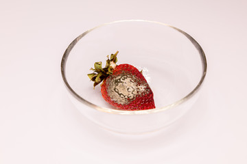 Spoiled product. Rotten strawberries .Close-up on a white background