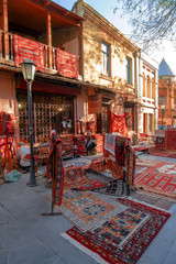 Tbilisi, Georgia, 18 December 2019 -  vintage style Oriental carpets stacks on a street carpets...