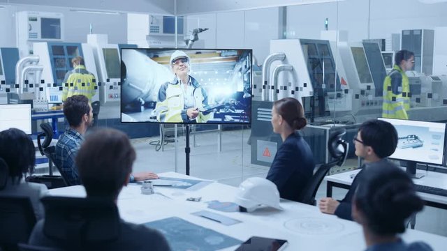 Diverse Group of Specialists, Managers in the Factory Office Meeting Room, Have Conference Video Call with Factory Chief Female Engineer, She Talks about Production Growth, Uses Tablet Computer