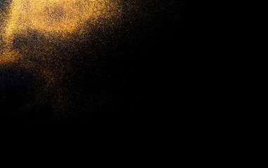 Fototapeta na wymiar Black background with golden sparkles. Blurred effect