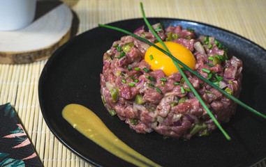 Steak tartar with egg on black plate