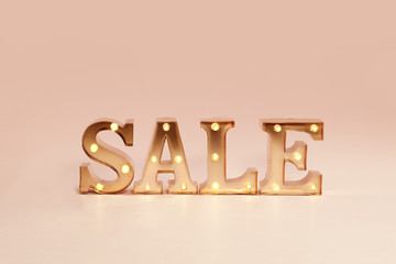 advertisement Sale illuminated metal letters at pastel background
