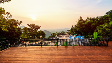 High angle viewpoint for watching the beautiful nature landscape colorful sky during the sunset. Table and chairs on the terrace for dining of the restaurant on the mountain, Chon Buri, Thailand, 16:9 - obrazy, fototapety, plakaty