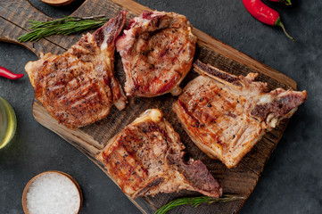grilled beef steaks with spices on a cutting board on a stone background 