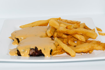 Argentinian food. Milanesa with bacon and cheese with french fries