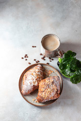 Cup of black coffee with foam and croissants on a light concrete background. Breakfast concept.