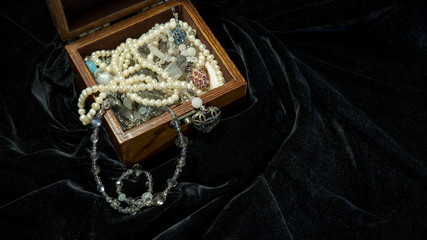 Jewerly box on the black satin with accessories for woman. Shiny natural sea pearl, ring and...