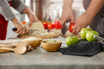 Hands in kitchen making meal.Table of free space for your decoration and fresh vegetables. 