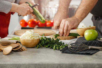 Hands in kitchen making meal.Table of free space for your decoration and fresh vegetables. 