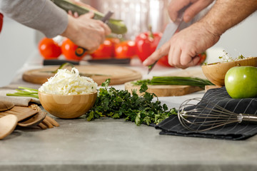 Hands in kitchen making meal.Table of free space for your decoration and fresh vegetables. 