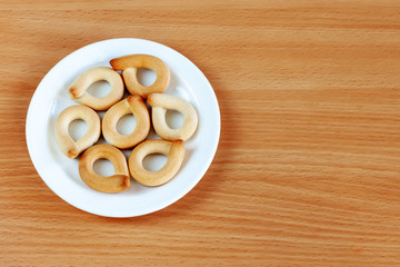 Sweet round crisps on a plate, fried in flour and sugar on a light brown background with space for text