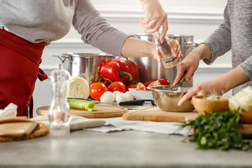 Hands in kitchen making meal.Table of free space for your decoration and fresh vegetables. 