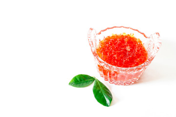 Red salmon caviar in a glass caviar bowl on a white background. Delicacy