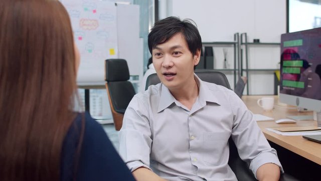 Asia businesspeople chatting to intern discussing job interview colleagues having conversation and meeting brainstorming ideas about project working plan success strategy in office. 4K Slow motion.