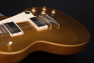Part of gold color electric guitar