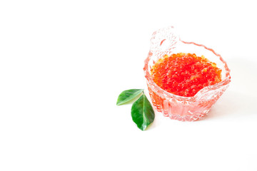 Red salmon caviar in a glass caviar bowl on a white background. Delicacy