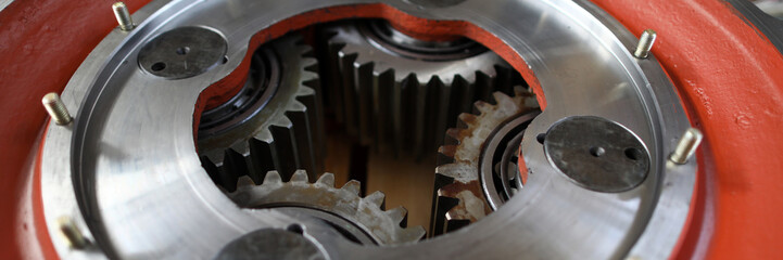 Big mechanical gear part with set of cogwheels inside close-up
