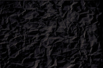 black crumpled paper texture with folds, black background, wallpaper.