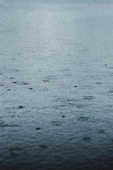 Rain droplets hitting water
