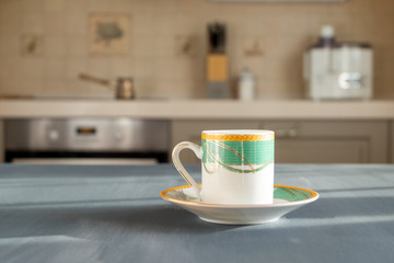 Coffee or teacup on a wooden surface of dark gray color on a blurred background of the kitchen