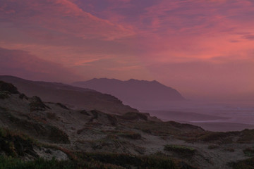 Fototapeta na wymiar Mountain Rising out of the sea at sunset