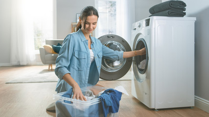 Beautiful and Happy Brunette Young Woman Comes Towards the Washing Machine in Homely Jeans Clothes....