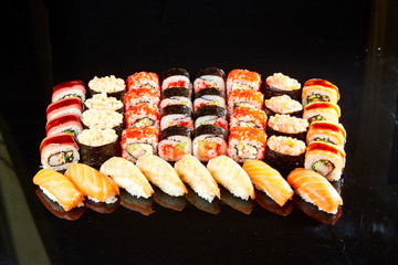 Various kinds of sushi roll set served on black stone. Japanese food