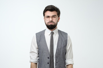 Young man looking camera puffing out cheeks from resentment.