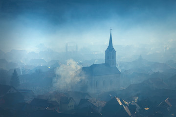 Fototapeta premium Church silhouette misty village landscape seen from above
