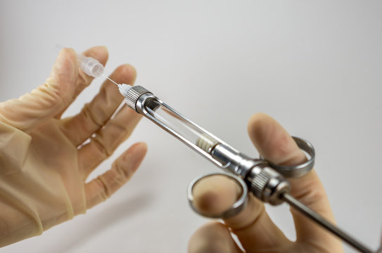 capsules for dental anesthesia and syringe, articaine procaine lidocaine mepivacaine in hand, choosing an anesthetic drug at a dentist's appointment