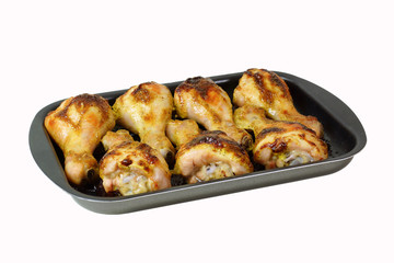 Fried chicken legs on a baking sheet. Isolated