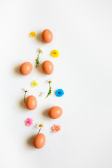 Easter pattern of Eggs with flowers petals and candies on the white background. Easter concept. Healthy feeding concept. 