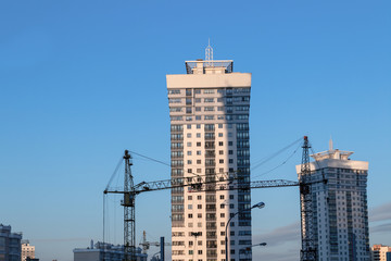 Multi-storey building, sunrise, construction crane, blue sky