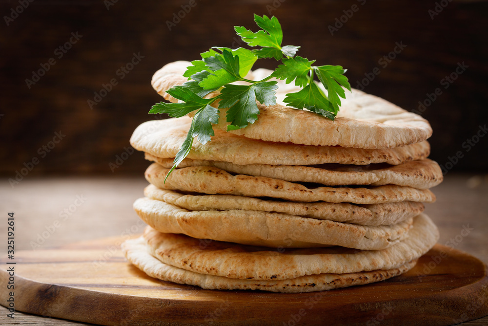 Sticker fresh pita bread on a wooden background