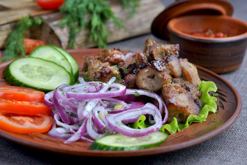 pork skewers with a side dish of vegetables